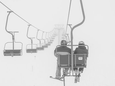 Skifahrer fahren mit dem Sessellift den Berg hoch | © Shutterstock