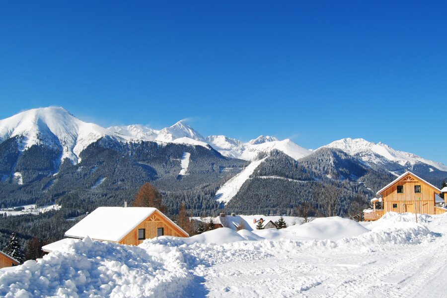 Winterpanorama mit Chalets Winterurlaub im eigenen Chalet verbringen