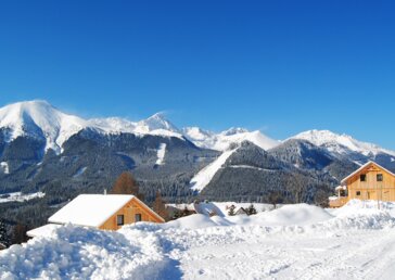 Winterpanorama mit Chalets Winterurlaub im eigenen Chalet verbringen