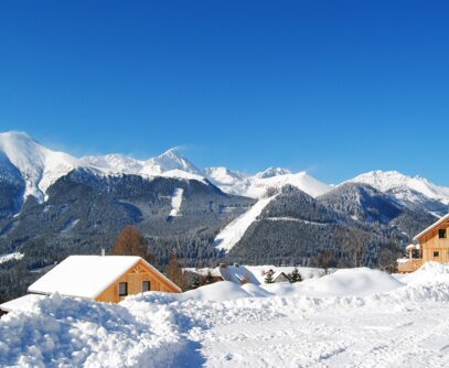 Winterpanorama mit Chalets Winterurlaub im eigenen Chalet verbringen